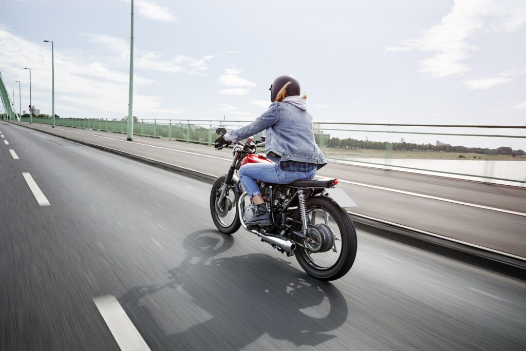Young woman riding motorcycle on bridge