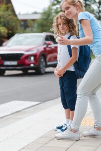 Sister explains to the little boy how to cross the street safely
